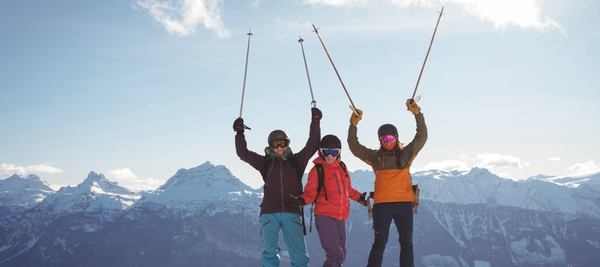 Des skieurs pointent leurs batons de ski vers le haut