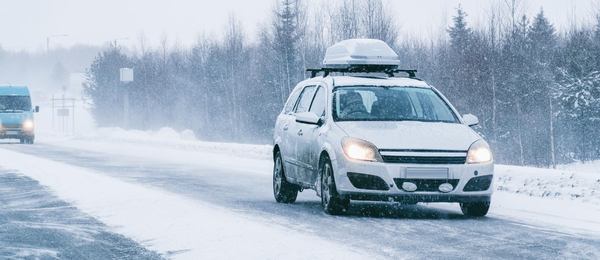 Une voiture qui roule sur une route enneigée 