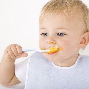 bebe qui mange son repas a la petite cuillère 