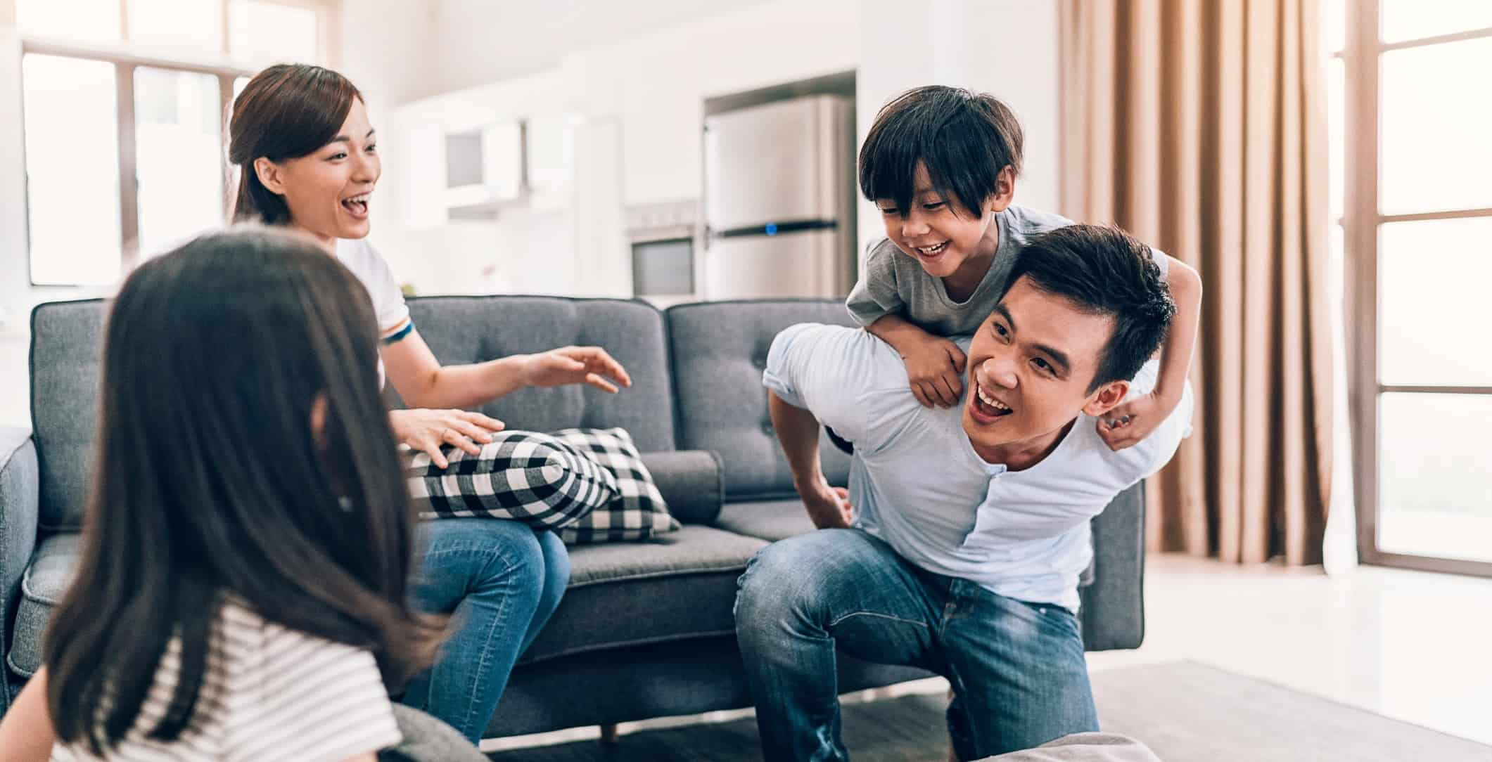 un père de famille qui porte son petit garçon sur son dos