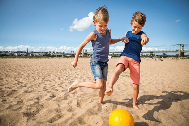 deux petits garçons au ballon sur la plage