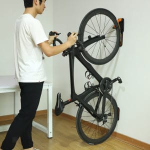 homme utilisant un porte-vélo mural 