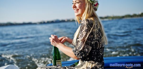 une femme au bord de la mer porte une bouteille de cava