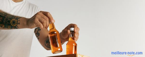 un homme porte deux bouteilles de cidre