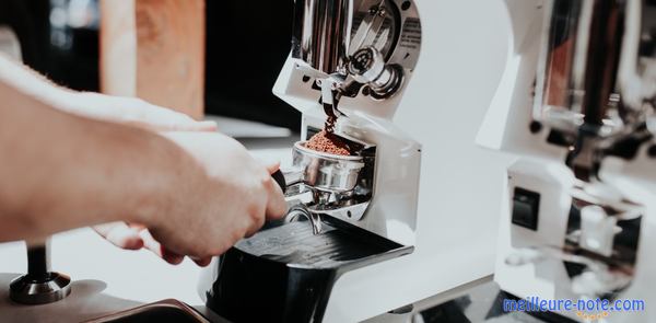 une main prend des cafés à une machine