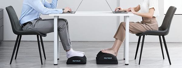 Un homme et une femme utilisant chacun un repose-pied de bureau