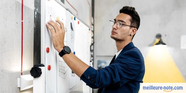 un homme écrit sur un tableau