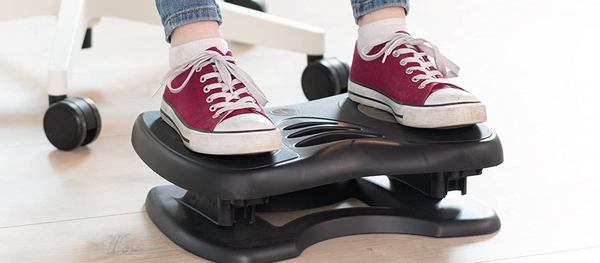 Des baskets plates sur un repose-pied de bureau