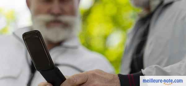 Deux monsieurs seniors avec un téléphone vintage