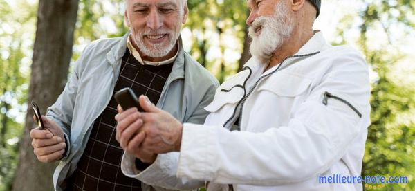 deux vieux monsieur se montrent leur téléphone