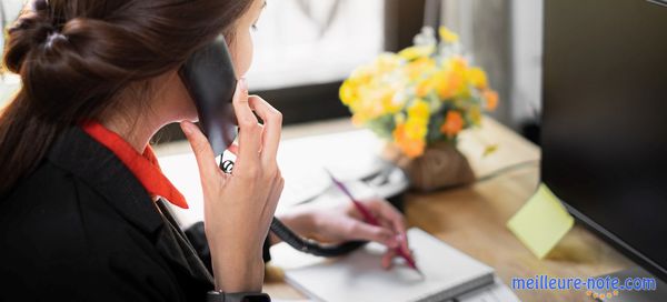 Une femme qui utilise le téléphone fixe