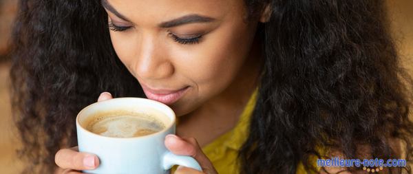 une femme prend une tasse de café