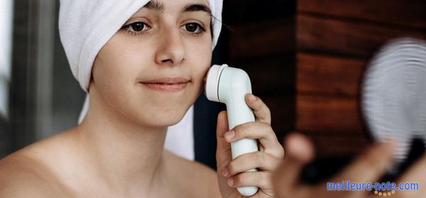 Une jeune femme utilise la brosse nettoyage du visage 