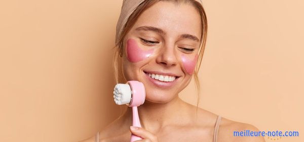 Une femme qui tient la brosse du visage