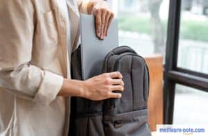 un homme range son laptop dans son cartable