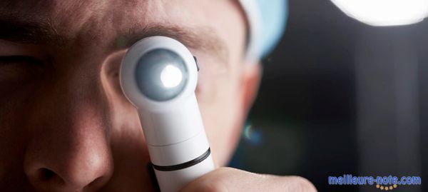 Un docteur qui tient un otoscope allumé 