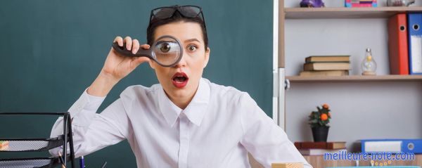 Une femme qui tient une loupe sur ses yeux