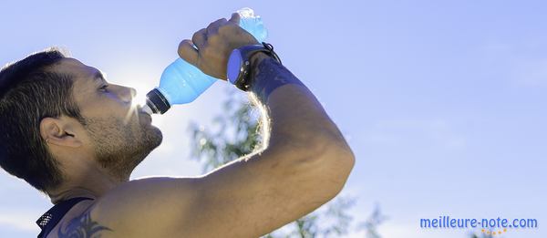 Un jeune homme musclé qui boit une boisson énergisante