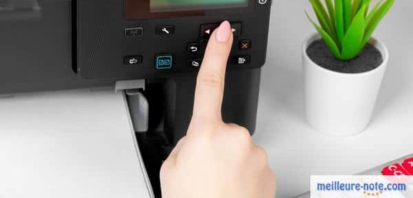 une main clique le bouton de l'imprimante