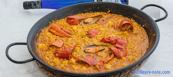 Une poêle à paella et des légumes