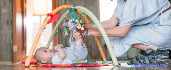 Un petit bébé qui s'allonge sur le tapis d'éveil