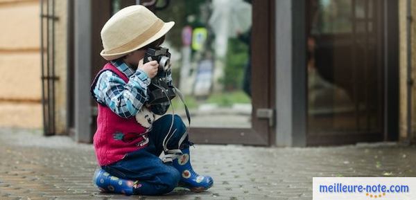 un petit garçon prend une photo