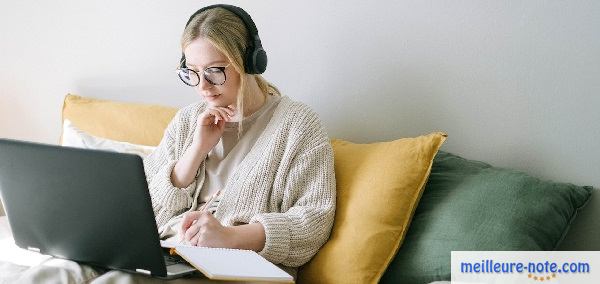 Une femme qui travaille sur son canapé avec un casque