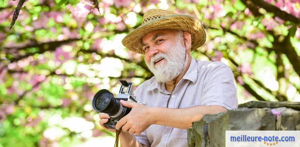 un vieux homme tient son appareil photo