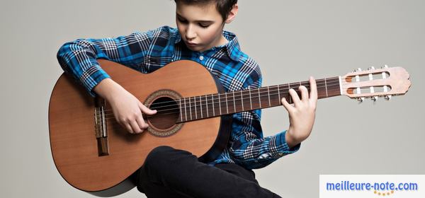 un petit garçon joue une guitare