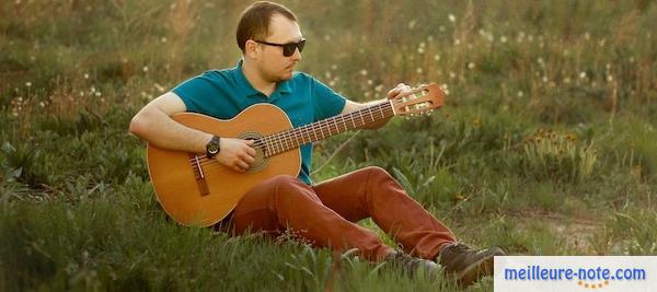 un homme avec sa guitare classique