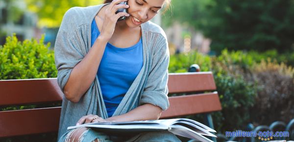 une femme téléphone regardant un livre