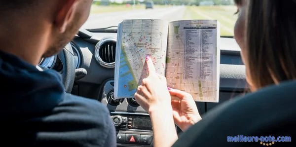 un couple regarde un guide dans la voiture