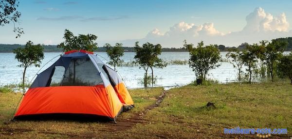 une tente orange au bord du lac