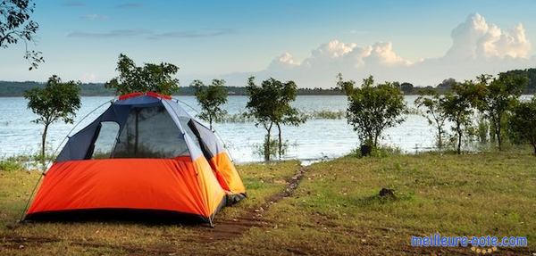 une tente orange au bord du lac