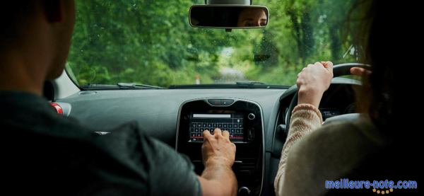 un couple regarde un écran dans une voiture