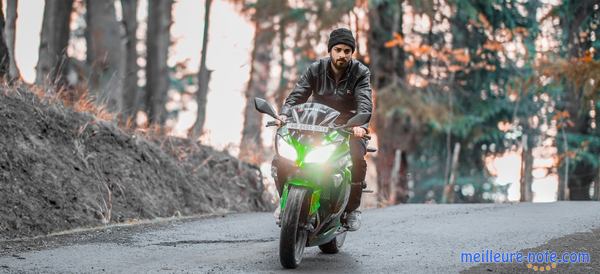 un homme avec sa moto sur la route