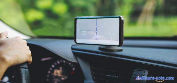 une main au volant et un téléphone sur le support