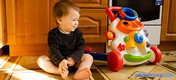 Un petit bébé joyeux qui regard le trotteur