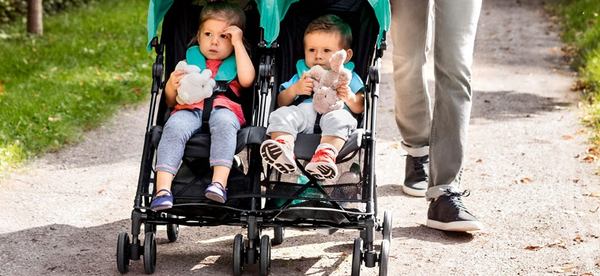 deux bébés dans une poussette double