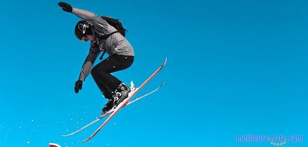 un homme qui saute avec son skis