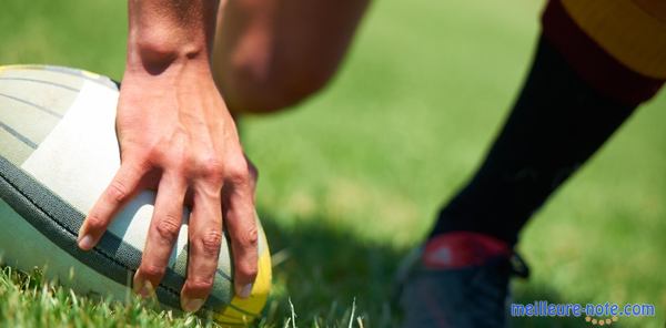 Une main qui tient un ballon de rugby