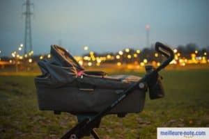 Une poussette photographié devant les lumières de la ville