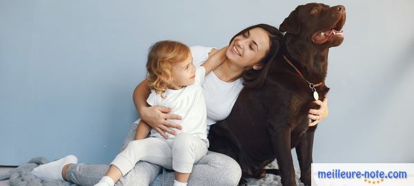 une femme porte un bébé avec un chien