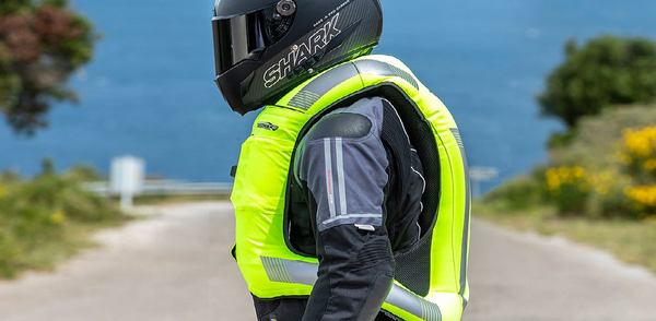 un homme avec un casque met un gilet vert