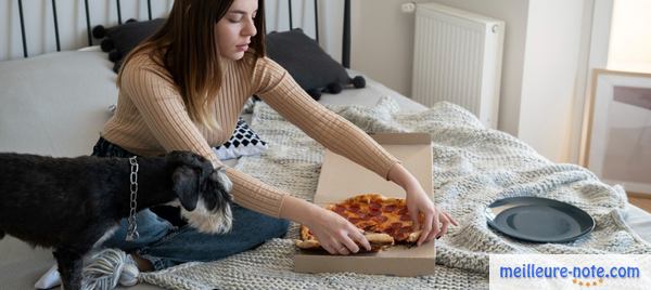 une femme mange près de son chien