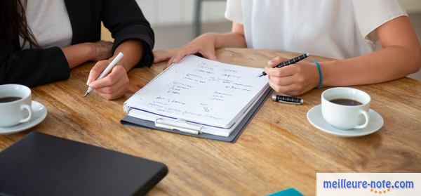 deux femmes qui écrient sur leur agenda