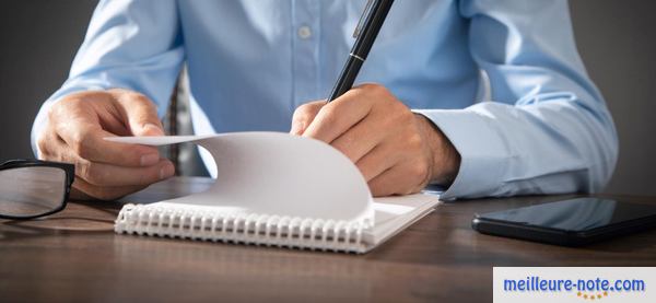 un homme écrit sur son cahier de texte