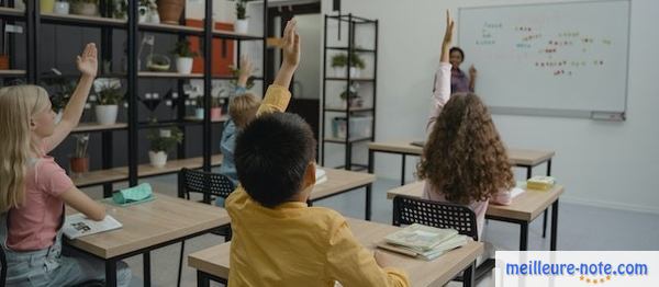 Des enfants qui lèvent leur main pour répondre à la maitresse