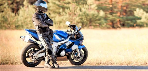 un conducteur moto à coté de sa moto