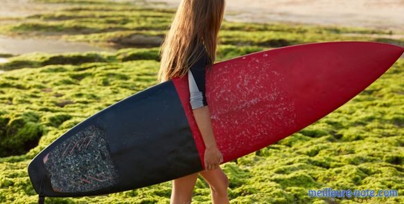 Une fille qui tient une planche de surf